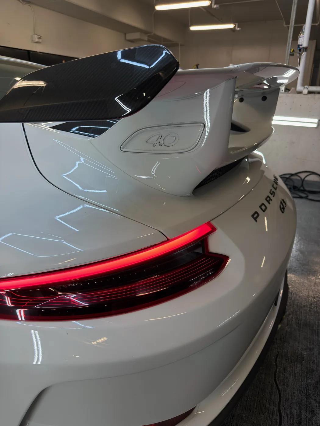 Porsche 911 GT3 rear after detailing — deep gloss, dust-free paint and carbon wing