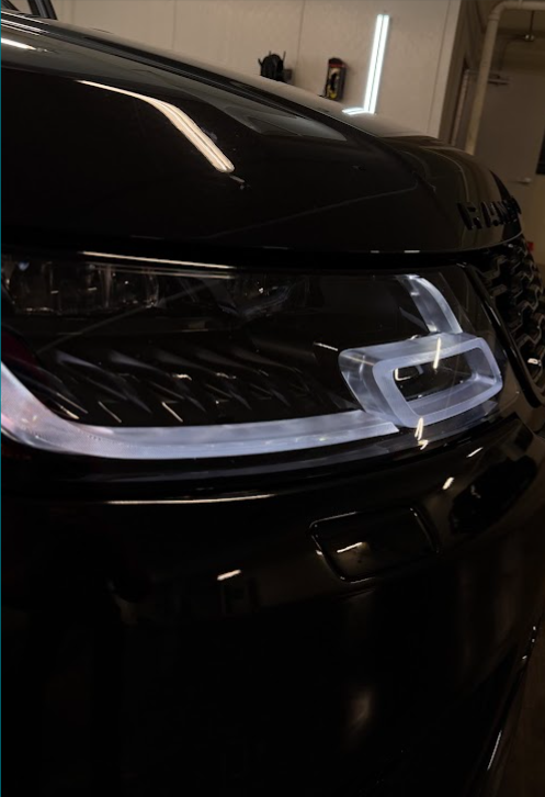 Close-up of glossy detailed Range Rover headlight and hood