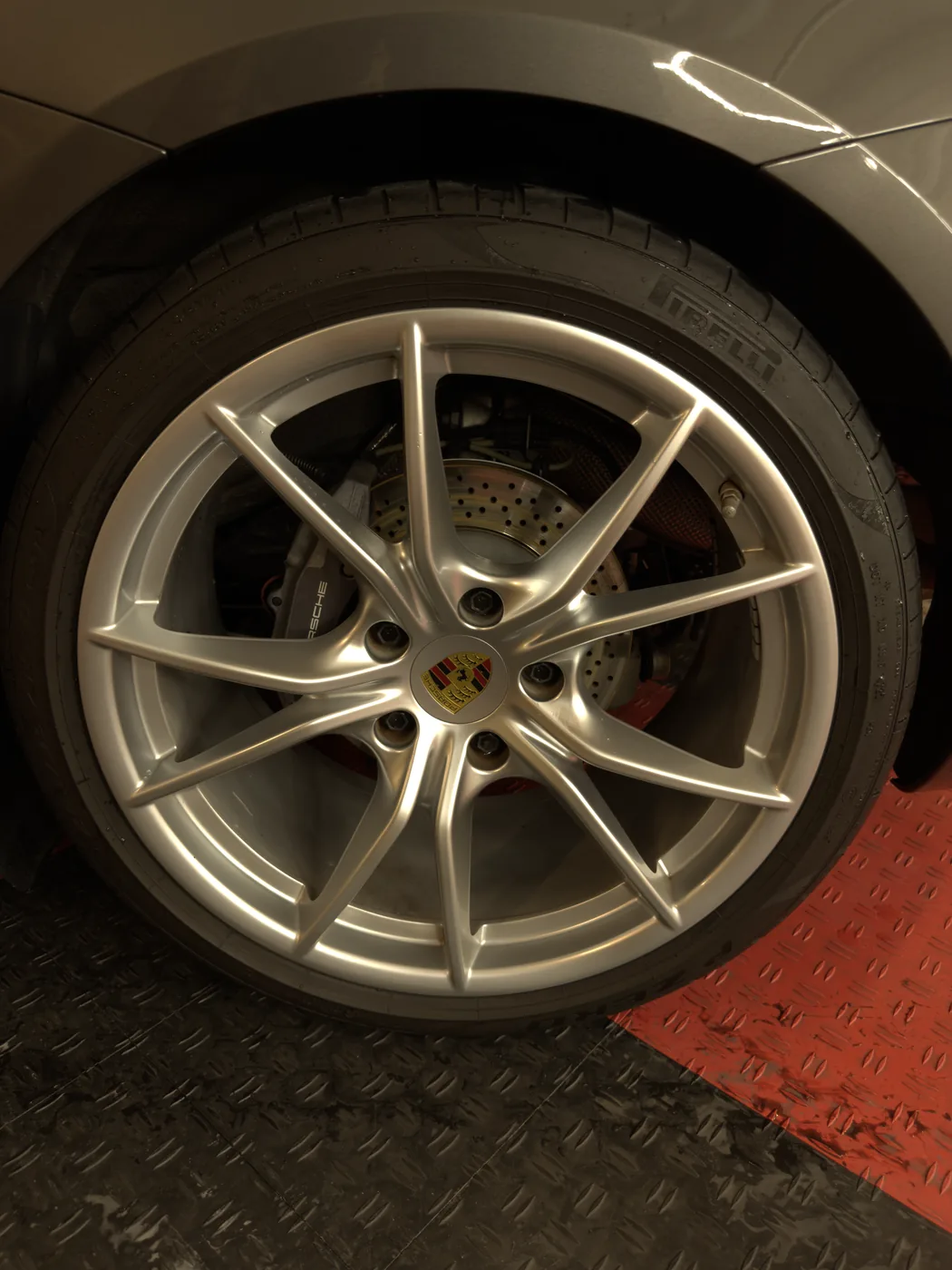 Close-up of glossy detailed Porsche wheel and brake caliper